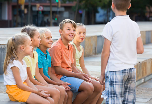 istock Smiling kids playing charades outdoors 1210775621