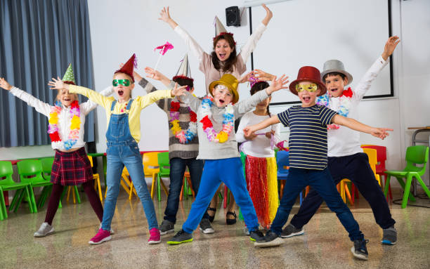istock Pupils and teacher with festive accessories posing together 1210775682