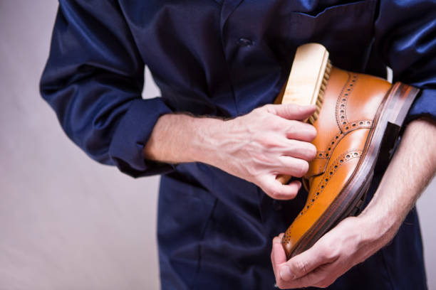istock Closeup of Mans Hands with Cleaning Brush Making Up Premium Derby Boots. Horizontal Image Orientation 1210777087