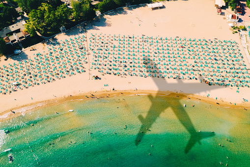 Shadow of an airplane flying over beach