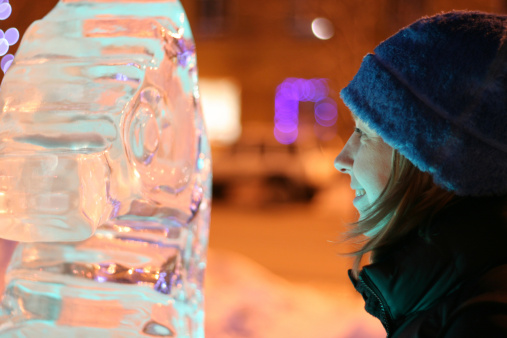 Smiling women with light reflecting from an ice sculpture