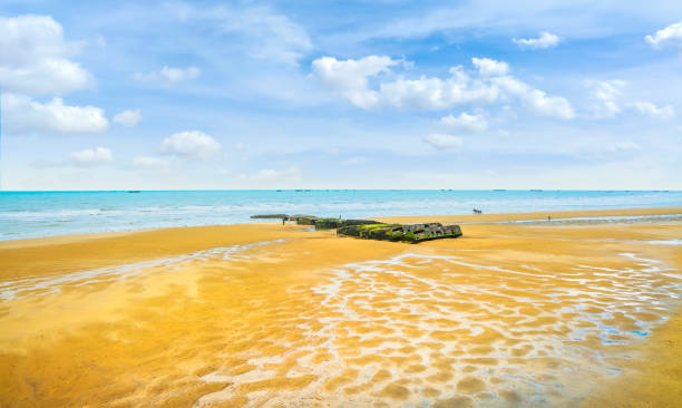 arromanches les bains, praia e restos do porto artificial. normandia, frança. - france sea allied forces atlantic ocean - fotografias e filmes do acervo