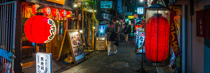 Traditional paper lanterns illuminating the narrow alleyways and popular restaurants of the Dotonbori Namba district of downtown Osaka at night, Japan.