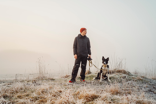 Man and his dog outdoors in rural nature on early morning
Photo taken in natural light of man in functional clothing and his border collie mixed breed dog