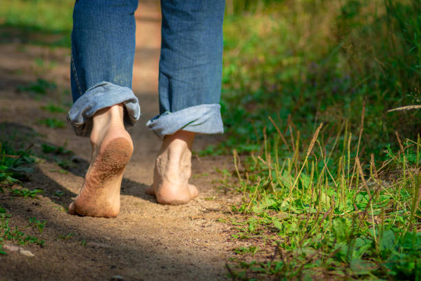 hombre caminando por el camino del bosque. primer plano de los pies descalzos ensuciado con tierra. estilo de vida saludable. - child human foot barefoot jeans fotografías e imágenes de stock