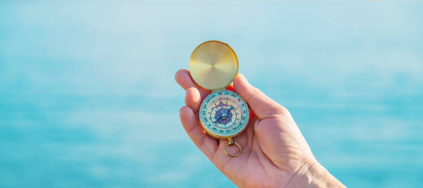 istock A man with a compass in his hands near the sea. Selective focus. 1210785904