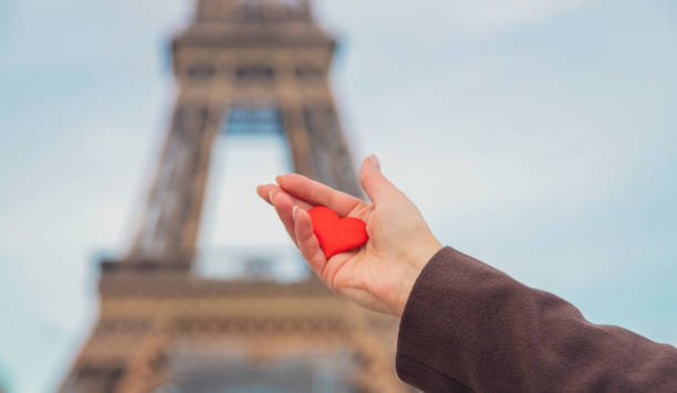 istock Heart in hands near the Eiffel Tower in Paris. Selective focus. 1210786036
