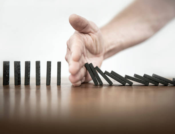 Domino Falling dominoes | Stop the domino effect clean and jerk stock pictures, royalty-free photos & images
