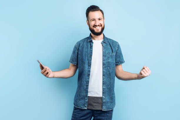 istock a man with a mobile phone, rejoices and celebrates the victory 1210788054