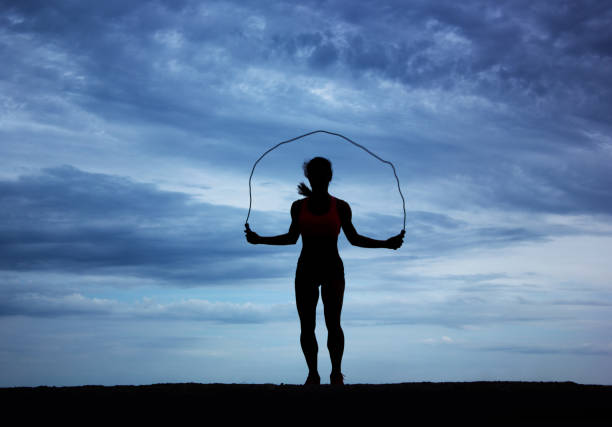 istock Women Silhouette jumping rope, sunset 1210788099