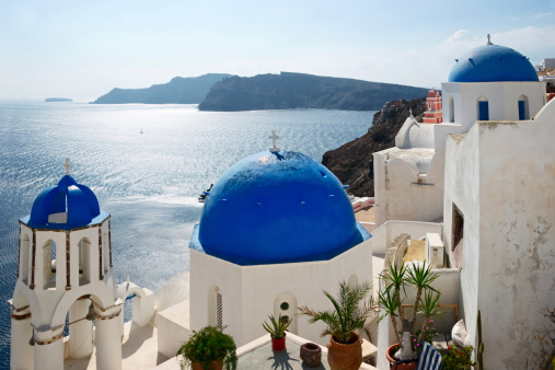 Famous Blue Domed churches on the sea background in Santorini, Greece.