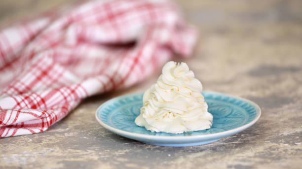 istock Whipped cream on blue plate, close-up. Vanilla cream 1210789437