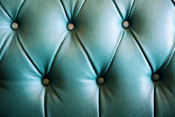 Green leather chesterfield sofa upholstery. Close up texture detail background.