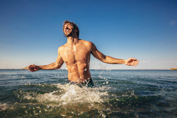 istock Handsome young man posing on the beach by the sea 1210798091