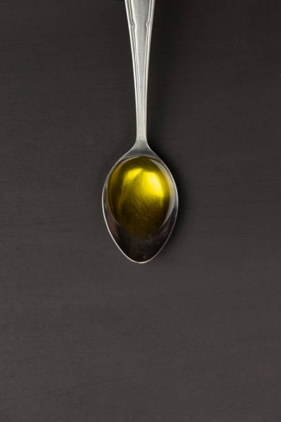 Wooden spoon and different spices on black background, close up