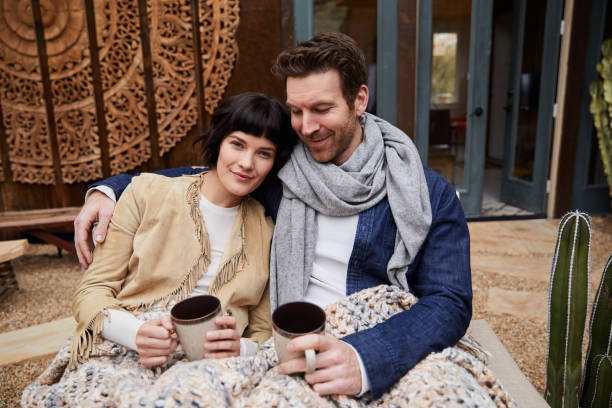 istock Content young couple sitting outside with coffees on a cool morning 1210799011