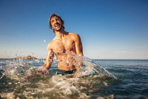 istock Handsome young man posing on the beach by the sea 1210799081