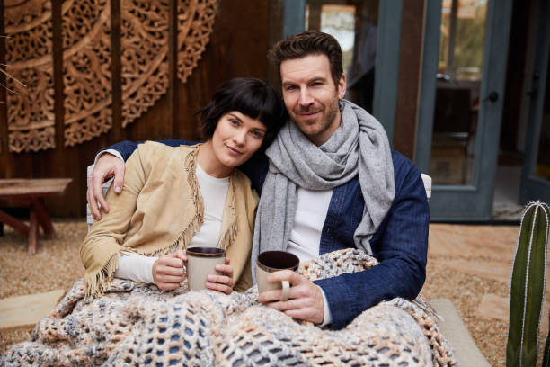 istock Content couple drinking coffee on a bench outside on a cool morning 1210799156