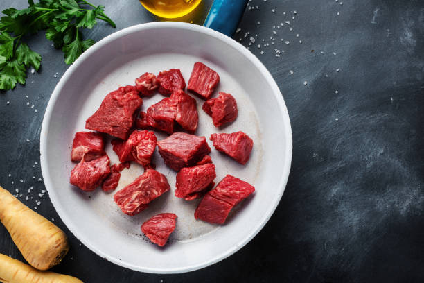 rindfleischstücke mit zutaten auf dem tisch serviert - stewing steak stock-fotos und bilder