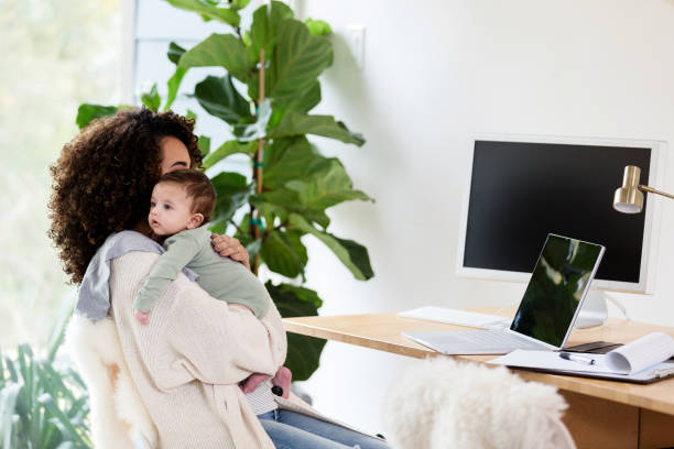 istock Mom works remote and holds newborn 1210806671