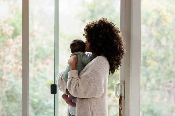 istock New mom and baby look out window 1210806682