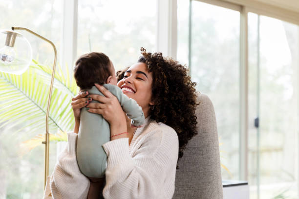 istock Smiling new mom holds tiny baby aloft 1210806692