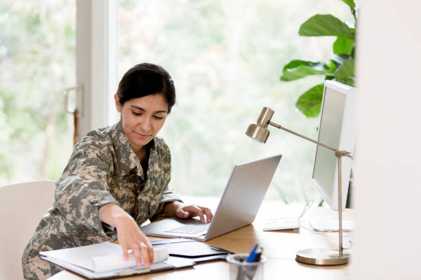 istock Female soldier works on home finances 1210807250