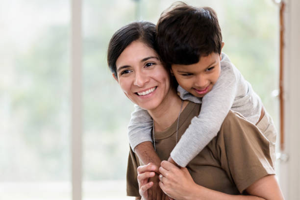 istock Mom carries her son piggyback 1210807266