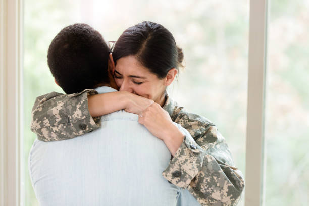 istock Upset female solder hugs husband goodbye 1210807284