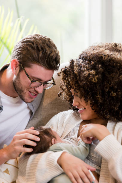 istock Dad smiles and touches baby while mom breastfeeds 1210807858