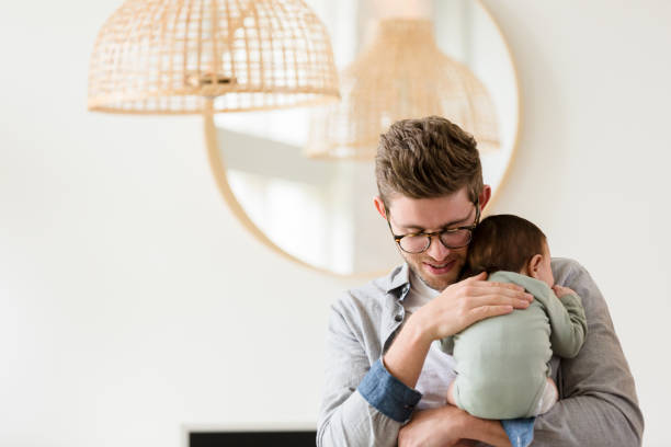 istock Dad holds baby up to shoulder and talks to him 1210807882
