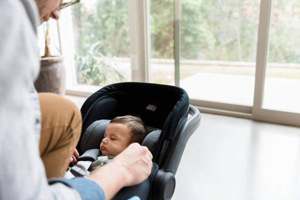 istock Unrecognizable father unbuckles sleeping baby from carseat 1210807888