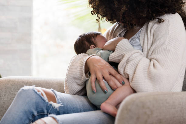 istock Unrecognizable mom holds baby snugly while breastfeeding 1210807897