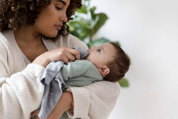 istock Mother looks in baby's eyes while wiping his face 1210807919