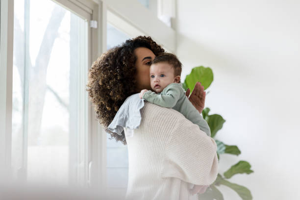 istock Young mother holds baby and pats his back 1210807921