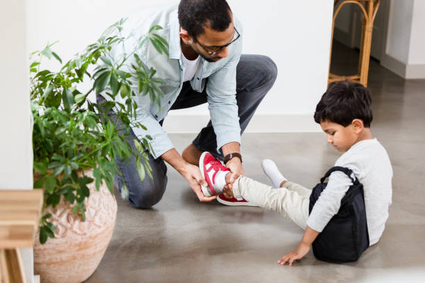 istock Dad helps his son put on shoes 1210808108