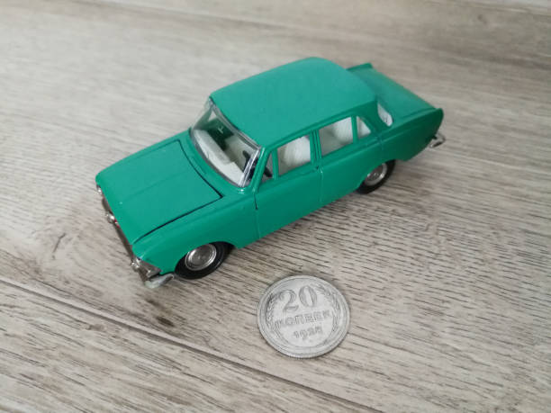 istock Car model toy in comparison with old coin 1210809212
