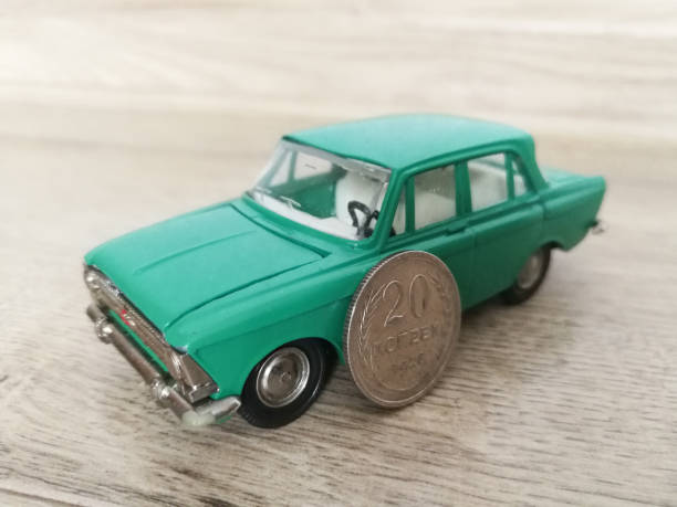 istock Car model toy in comparison with old coin 1210809229