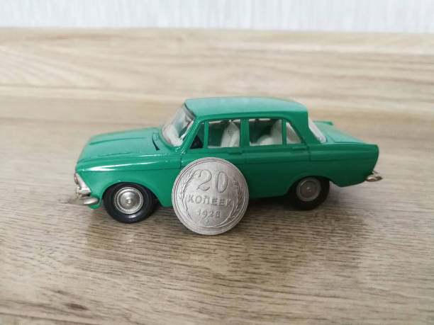 istock Car model toy in comparison with old coin 1210809239