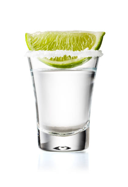 tequila glas schuss mit limettenscheibe und salzigen rand, isoliert auf weißem hintergrund - shot glass stock-fotos und bilder