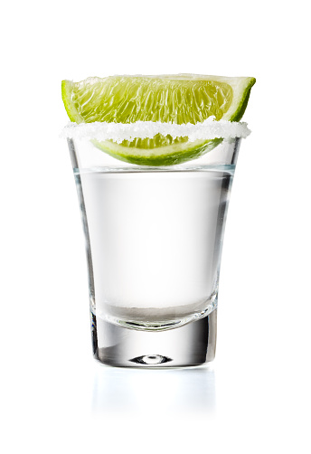 Tequila Glass Shot con rodaja de lima y borde salado, aislado sobre fondo blanco photo