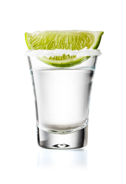 colpo di vetro tequila con fetta di lime e bordo salato, isolato su sfondo bianco - shot glass foto e immagini stock