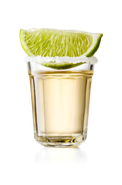 złoty tequila szkło strzał z plasterka limonki i słonej obręczy, izolowane na białym tle - drink mexican culture tequila shot tequila zdjęcia i obrazy z banku zdjęć