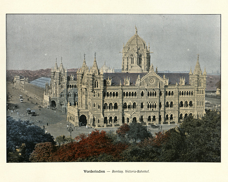 Vintage colourised photograph of Victoria Terminus, Bombay, India, late 19th Century. The terminus was designed by British born architectural engineer Frederick William Stevens, in an exuberant Italian Gothic style. Its construction began in 1878 and was completed in 1887