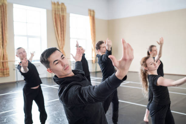 istock Young handsome man with outstretched arms doing one of dance exercises 1210811861
