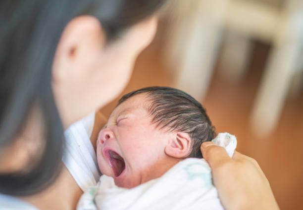 mère tenant son fils nouveau-né qui est yawning photo stock - baby yawning asian ethnicity newborn photos et images de collection