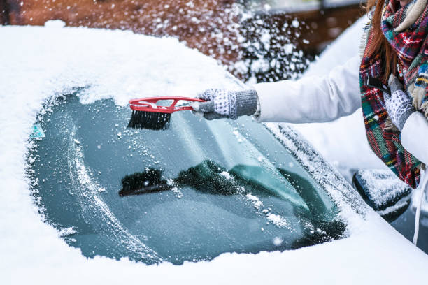kobieta czyszcząca śnieg z przedniej szyby, skrobanie zamarzniętego szkła lodowego. samochód zimowy czyste przednie szyby - snow car window ice scraper zdjęcia i obrazy z banku zdjęć