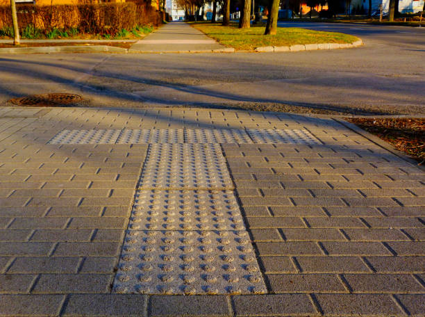 bumpy textured concrete pavement section at end of sidewalk - block interlocked danger warning sign imagens e fotografias de stock