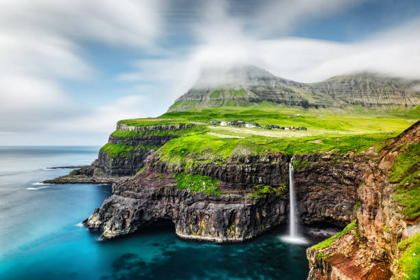 Mulafossur waterfall in Gasadalur, Vagar Island of the Faroe Islands Incredible day view of Mulafossur waterfall in Gasadalur village, Vagar Island of the Faroe Islands, Denmark. Landscape photography vágar photos stock pictures, royalty-free photos & images