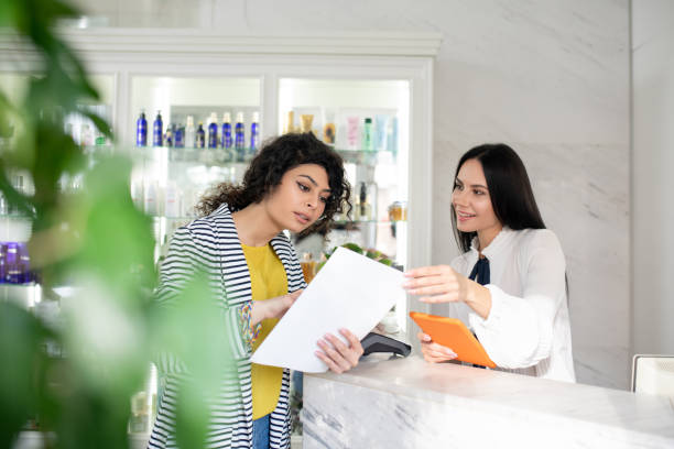 istock Dark-haired female customer asking the shop assistant about prices 1210819343